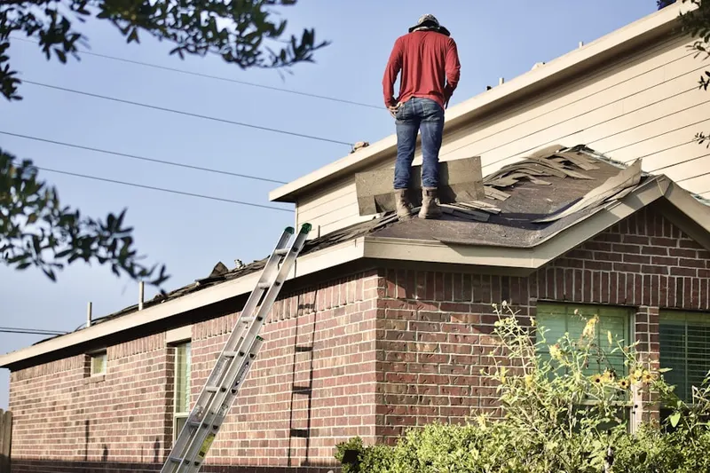 Professional roofer working on a residential roof in East Gloucester